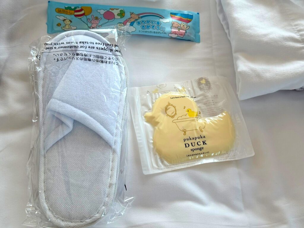 大阪ステーションホテルの子ども用アメニティセットの中身。歯ブラシ、スリッパ、アヒルのスポンジなど子どもが喜ぶアイテムが揃っている。