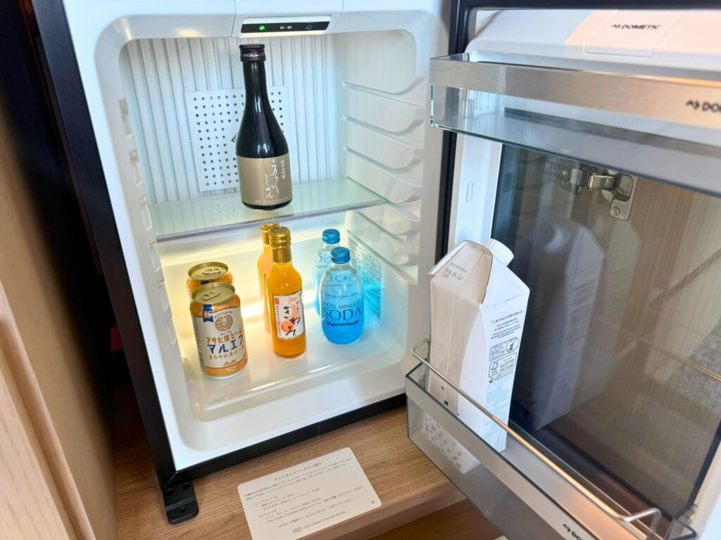 大阪ステーションホテル スペシャリティルームの冷蔵庫。ビールやジュース、日本酒などが並び、ウェルカムドリンクとして無料で提供されている。