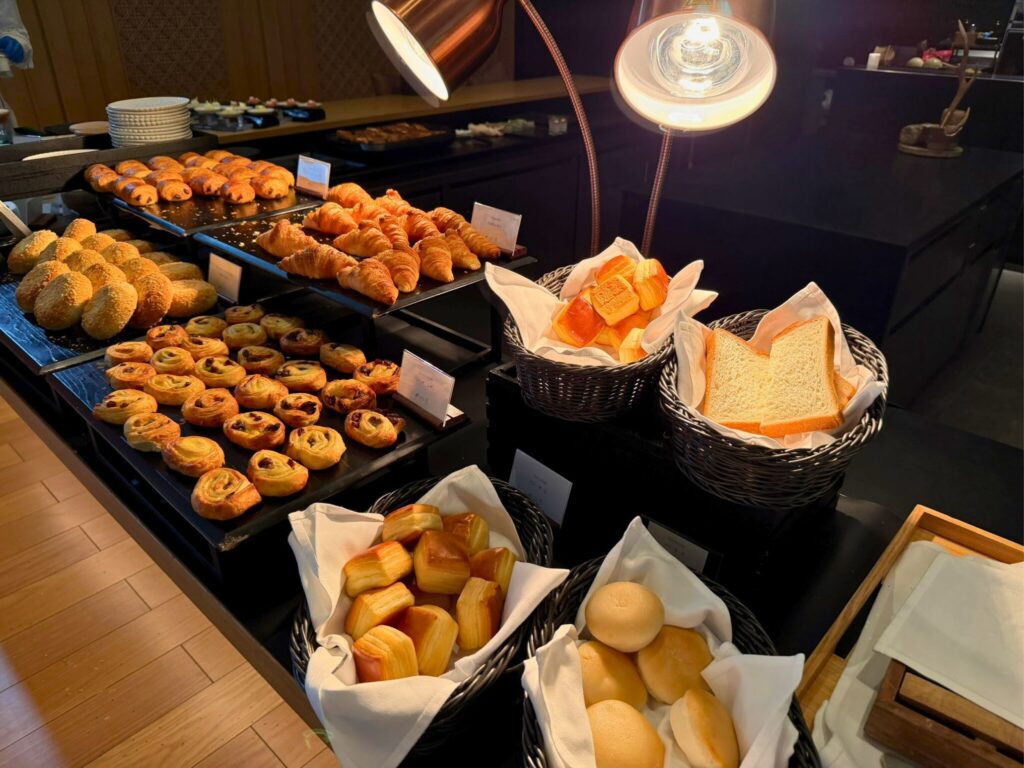 ROKU京都の朝食パンコーナー。クロワッサンやデニッシュなど焼きたてパンが並ぶ。