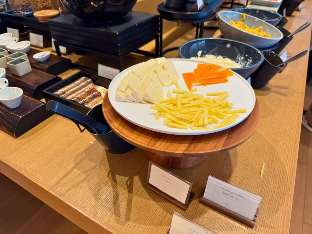 ROKU京都「TENJIN」朝食のチーズセレクション。カマンベールやハードチーズなどが並ぶ。