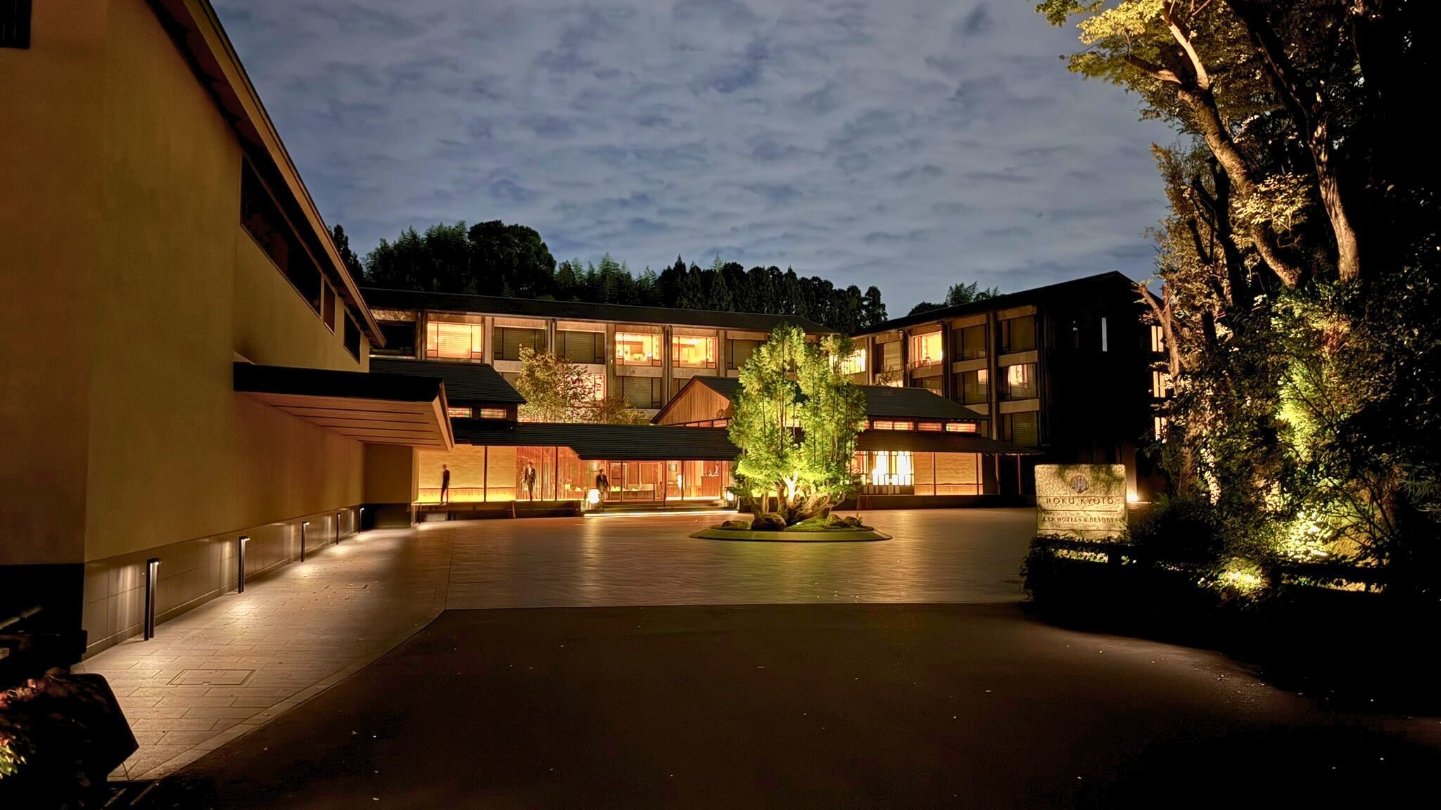 夜のROKU京都ホテル外観。中庭の樹木がライトアップされ、静寂に包まれたラグジュアリーな雰囲気。