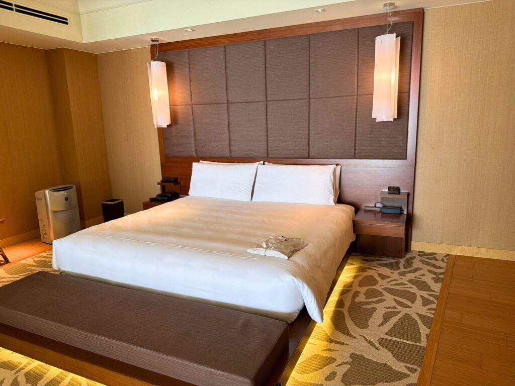 志摩観光ホテル ザ・ベイスイートのベッドルーム。キングサイズベッドと落ち着いた照明のラグジュアリーな客室。