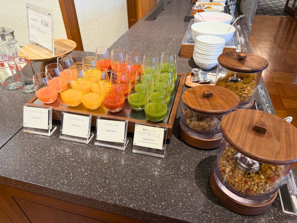 オレンジ、グレープフルーツ、野菜ジュースとシリアルが並ぶ志摩観光ホテルの朝食ビュッフェ。