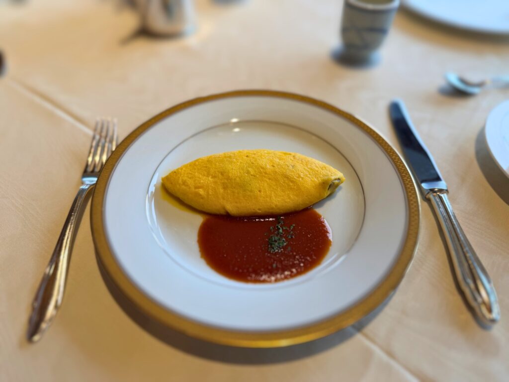 「ラ・メール」スタイルの海の幸オムレツ。トマトソースが添えられた朝食の卵料理。