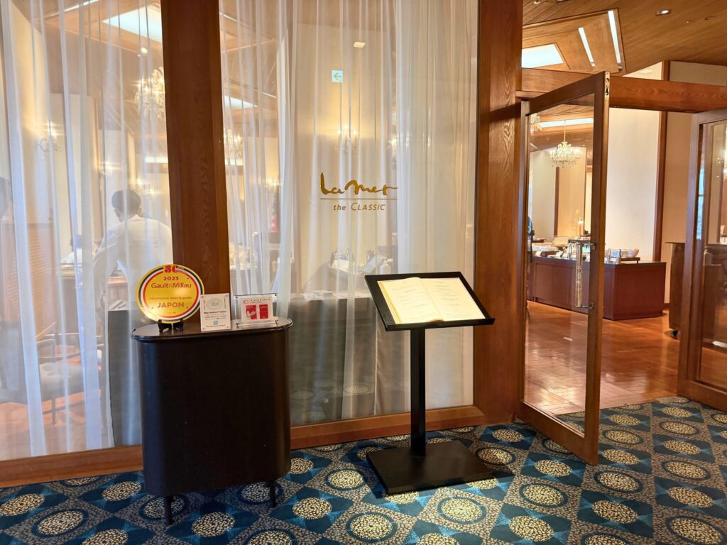 志摩観光ホテル「ラ・メール ザ クラシック」朝食会場の入口とメニュー台の様子。