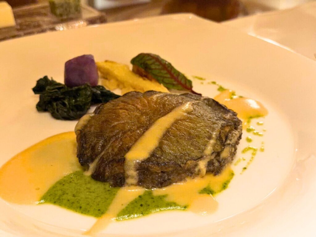 志摩観光ホテルのメイン料理「鮑ステーキ」。2種類のソースで味わう看板メニューで、柔らかく旨味が凝縮した一皿。