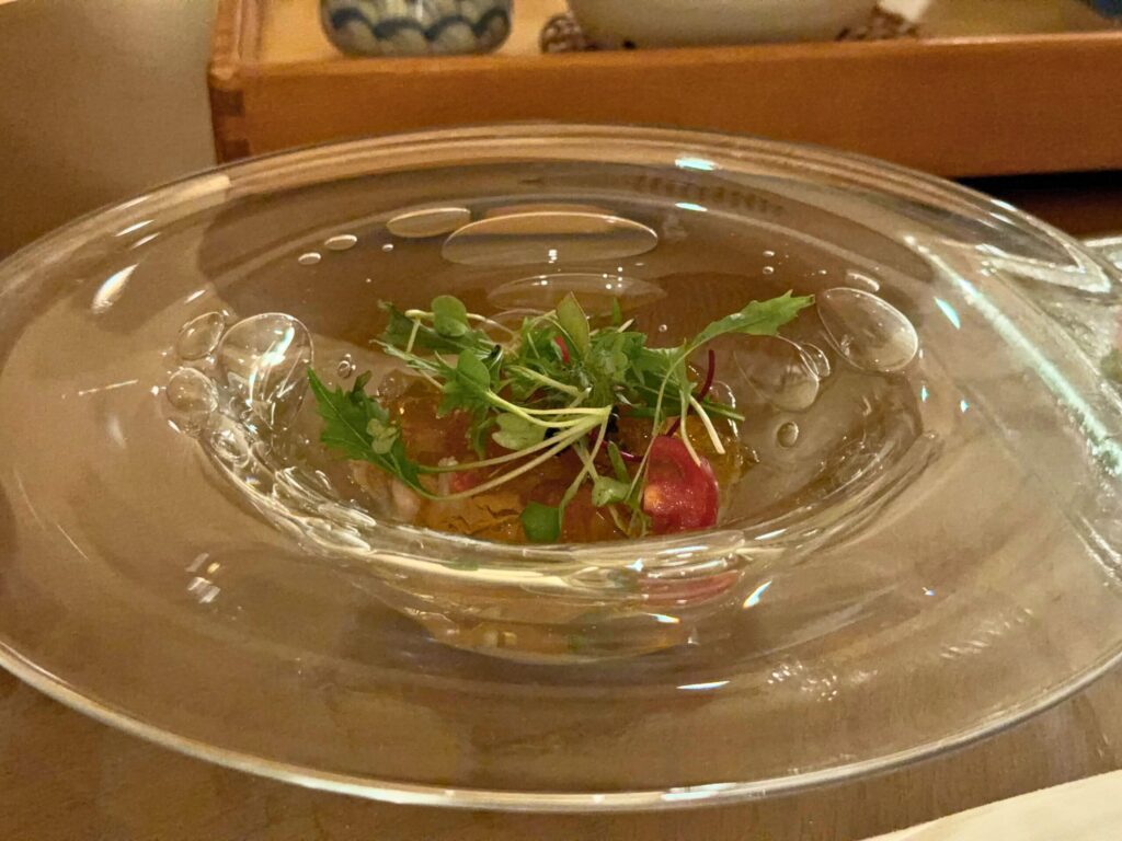 志摩観光ホテルの海の幸 甲殻類のジュレ。ガラス皿に盛り付けられ、海老や野菜の旨味が凝縮された冷前菜。