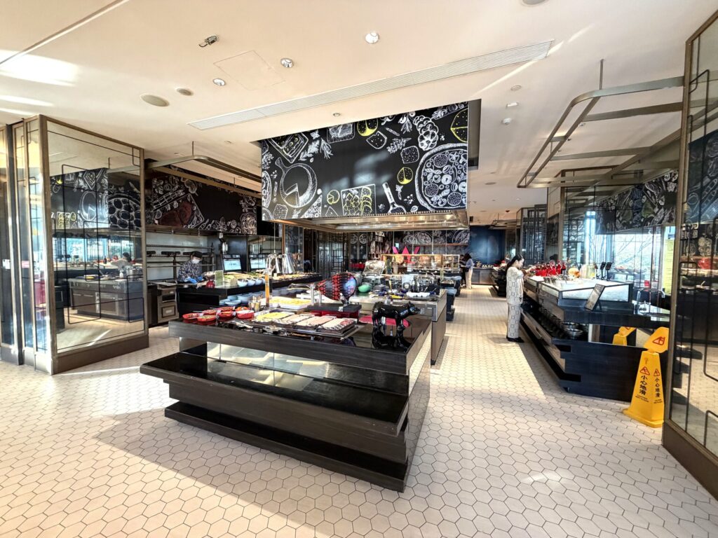 W蘇州ホテルの朝食ビュッフェのレストラン内観。黒板アートの大きな天井ディスプレイと黒いビュッフェカウンターが連なる広大なダイニング空間
