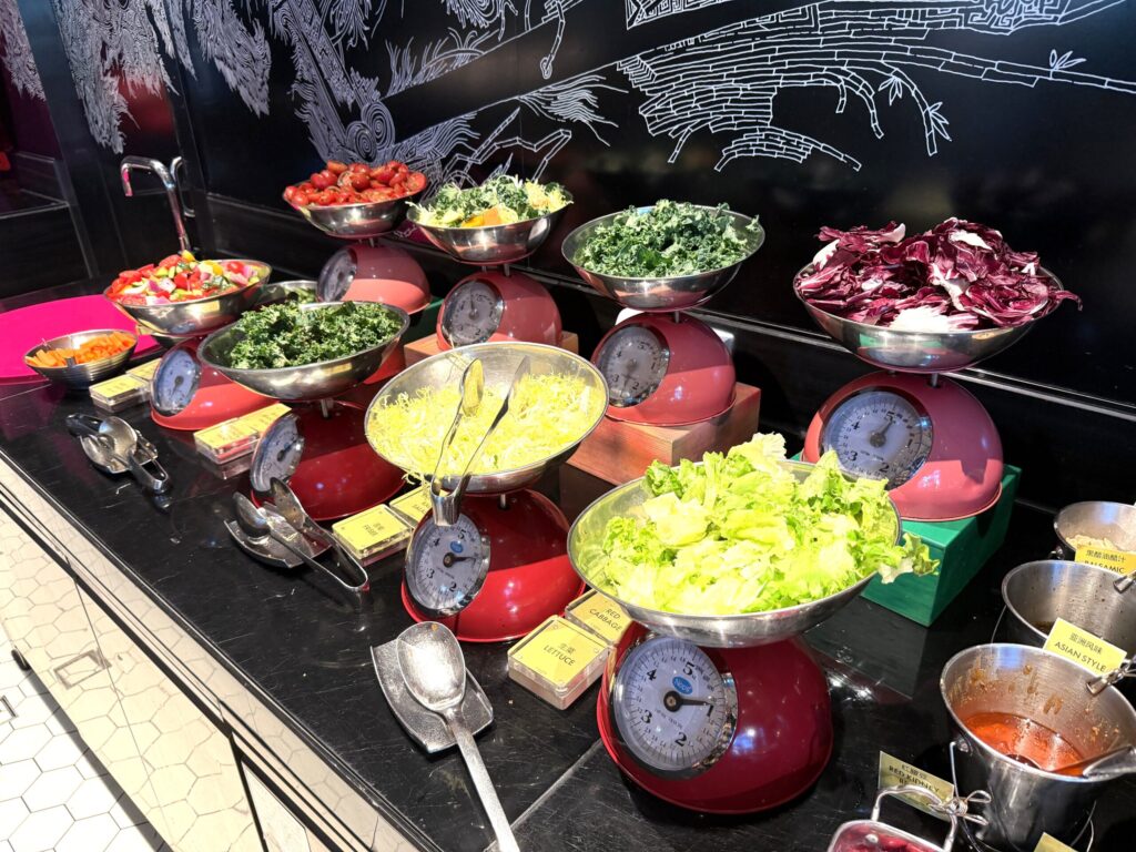 W蘇州ホテルの朝食ビュッフェのサラダバー。レトロなはかりスタンドに盛られたケール・レタス・トマト・紫キャベツなど彩り豊かな新鮮野菜が並ぶ