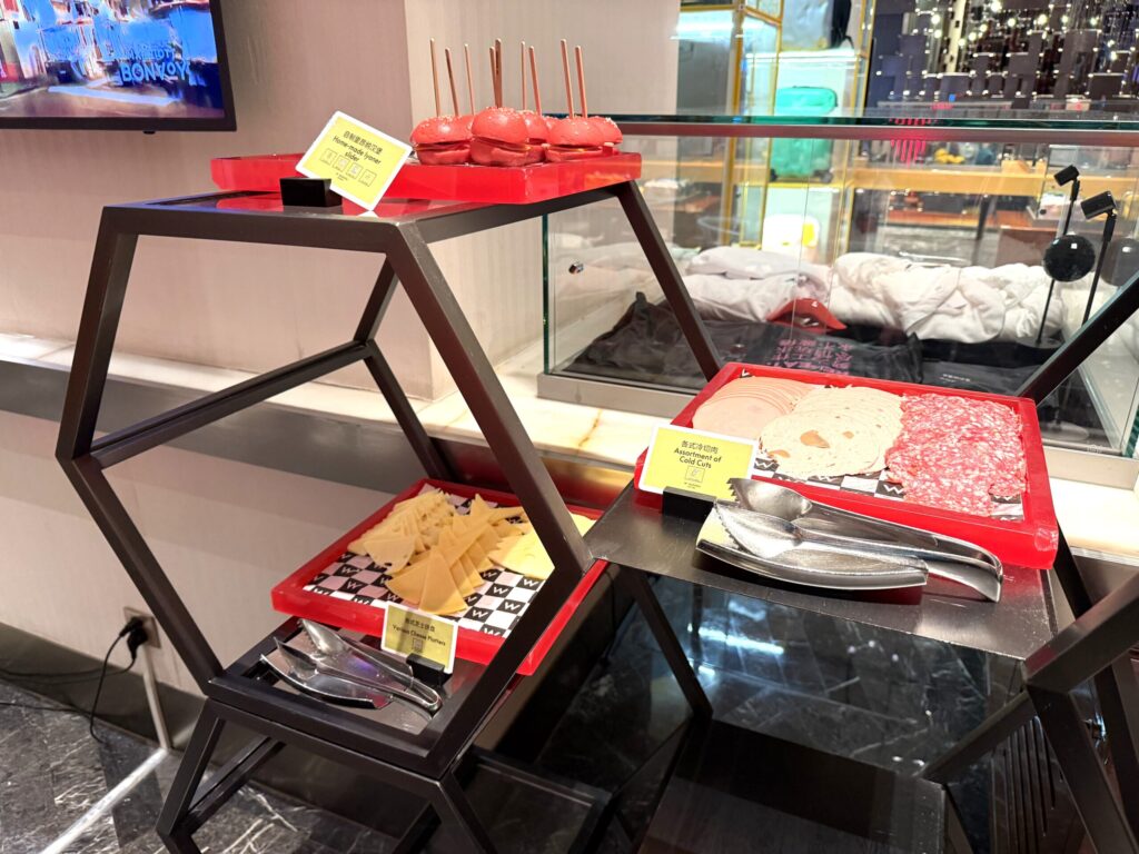 W蘇州ホテルのハッピーアワーの2段デザートディスプレイ。赤いキャンディーアップル風スイーツとチーズケーキ風デザートがスタイリッシュに飾られている