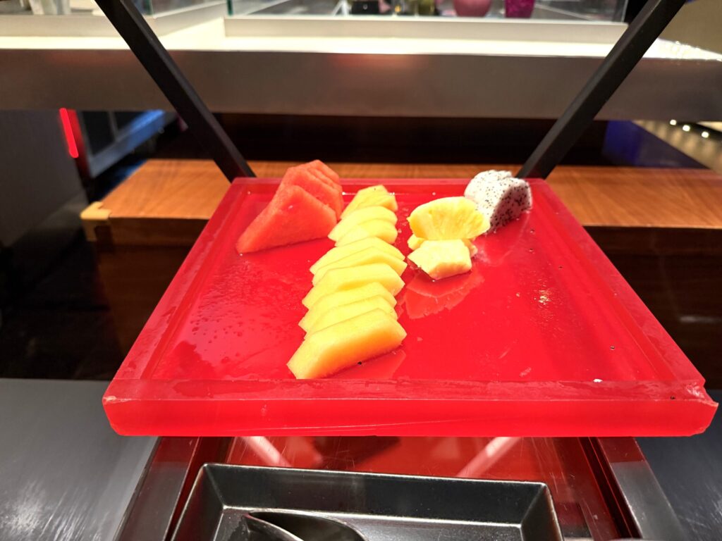 W蘇州ホテルのハッピーアワービュッフェ。赤いプレートにスイカ・マンゴー・パイナップル・ドラゴンフルーツのカットフルーツが美しく並べられている