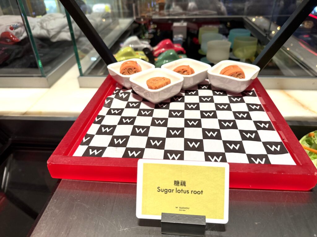 W蘇州ホテルのハッピーアワー。Wロゴのチェッカーボードトレイに白い器に盛られた糖藕(シュガーロータスルート)が並ぶ中華スイーツ