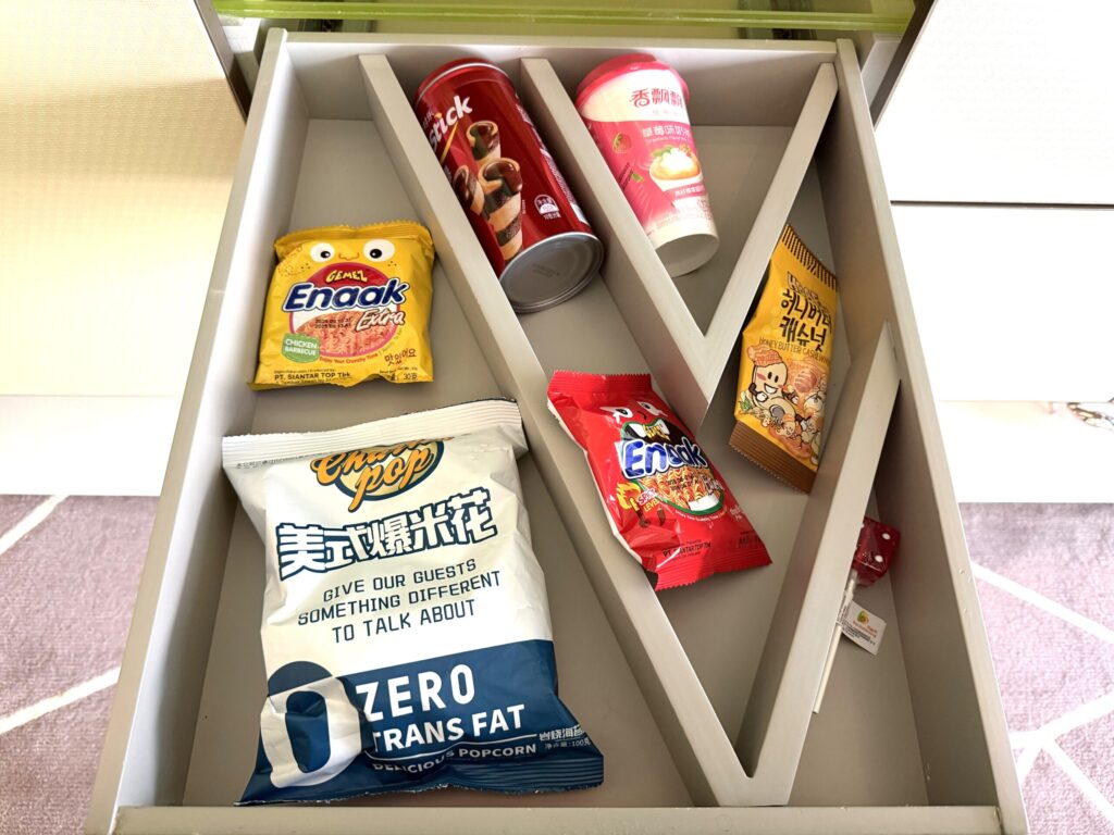 W蘇州ホテルの客室スナックドロワー。引き出し式の収納にポップコーン、Enaakスナック、カップ麺など多彩なスナック類が並ぶ